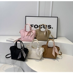 Group shot of leather bucket bags in five colors with decorative scarves and thin straps