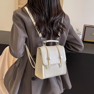 Chic cream white textured leather backpack worn by a model in a premium urban setting