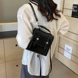 Fashionable black textured leather backpack for women with vintage flap and silver accents