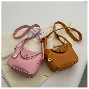 Détail de sacs seaux en cuir grainé rose et orange avec fermoir rotatif en métal doré