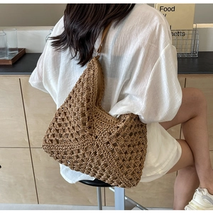 Close-up of brown woven hollow-out hobo bag with premium leather shoulder strap
