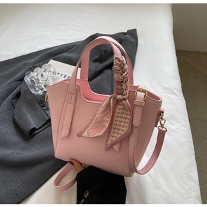 Pink lychee leather bucket bag detail with decorative floral scarf on handle