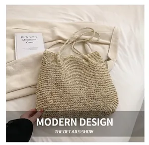 Detail shot of a beige hand-woven straw tote bag with fine texture on a white fabric surface