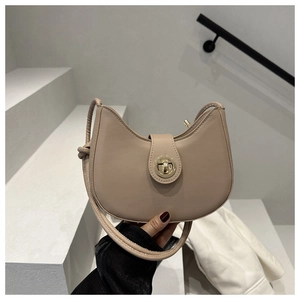 Gros plan sur le sac croissant beige avec boucle dorée et texture de cuir de haute qualité