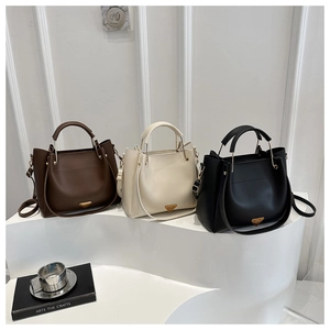 Three premium leather bucket bags in brown, beige, and black with golden triangle logo