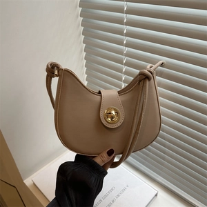 Sac hobo beige en demi-lune avec fermoir doré et bandoulière à nœuds élégante