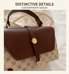 Close-up of vintage bicolored handbag featuring floral patterns and gold metal buckle detail