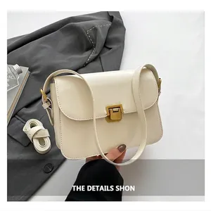 Close-up of minimalist cream white square bag featuring premium golden square push lock