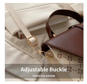 Detail of adjustable leather strap with gold metal buckle on retro floral crossbody bag