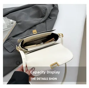 Detail view of cream crossbody bag interior with three compartments showing storage capacity