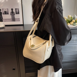 Sac seau blanc en cuir à motif litchi présenté dans un intérieur minimaliste