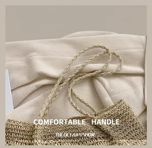 Close-up of dual twisted rope handles and fine woven texture of straw tote bag