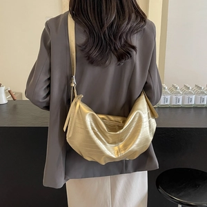 Metallic gold slouchy crescent tote bag with textured faux leather and adjustable strap