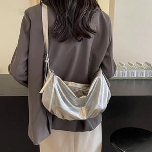 Silver crocodile pattern tote bag with adjustable strap worn by a model in casual style