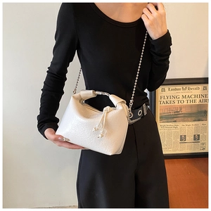 Dettaglio borsa in pelle bianca stropicciata con catena d'argento e chiusura a coulisse