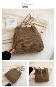 Detail of khaki straw tote bag with fine weave texture and slim shoulder straps