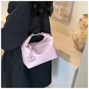Dettaglio borsa rosa in pelle plissettata con catena argento e ciondoli decorativi
