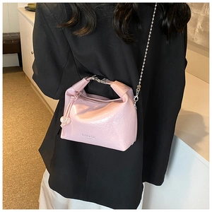 Dettaglio della borsa rosa lucida con catena a sfere d'argento e decoro di perle