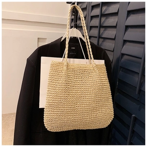 Detail shot of the natural woven texture and craftsmanship of the straw tote bag