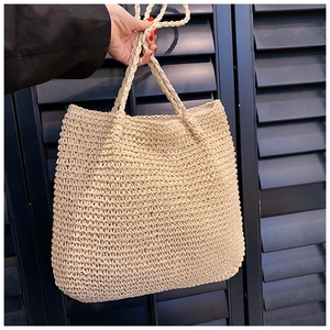 Close-up of beige woven tote bag showing the textured crochet pattern and handles