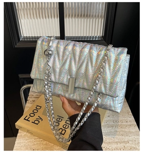 Gros plan du sac matelassé argent holographique avec motif en V et bandoulière en chaîne