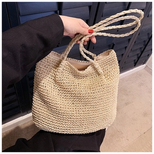 Detail of hand-woven straw tote bag with circular handles for summer beach style