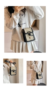 Detailed view of the women's small square crossbody bag in khaki and black trim.