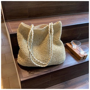 Detail view of woven beige straw tote bag showing thick rope texture and fabric lining
