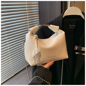 Dettaglio della borsa in pelle pieghettata bianca con manico in metallo argento