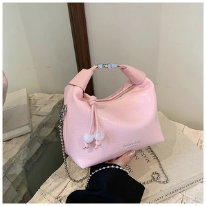 Dettaglio della texture in pelle PU rosa stropicciata e catena a sfere argentate della borsa