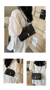 Détail du sac à bandoulière matelassé noir avec chaîne argentée et boucle métallique fine