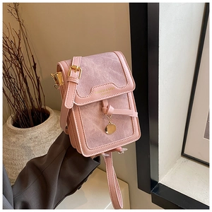 Detailed close-up of pink crossbody phone bag featuring a stylish knot detail and leather texture