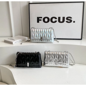 Détail de sacs à chaîne matelassés en holographique, argent et noir avec coutures en V