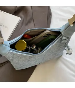 Detailed interior view of quilted denim bag showing storage capacity and zipper pocket