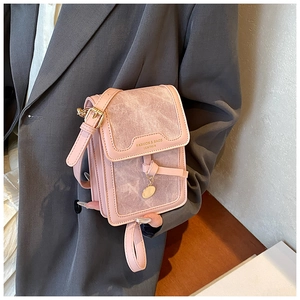 Detailed view of pink crossbody phone bag with gold charm and knot texture detail
