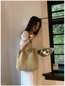 Detail of woven straw tote bag texture and long shoulder strap in minimalist style