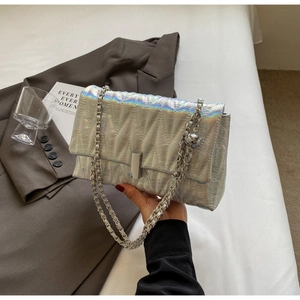 Détail d'un sac matelassé argent holographique avec chaîne en métal et fermoir chic