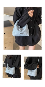 Detail of light blue quilted half-moon shoulder bag with JINGPIN logo and knot detail