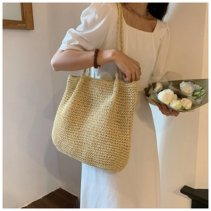 Macro detail of natural straw weave texture on a large beige summer tote bag