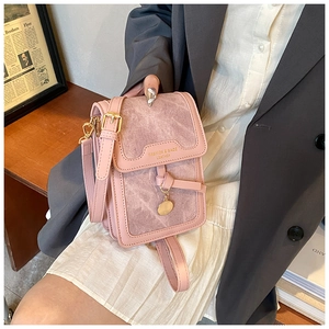 Pink minimalist crossbody bag with gold hardware and logo detail shown on a model