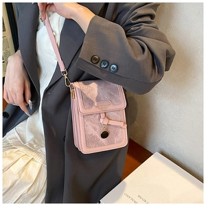 Detail of pink crossbody bag featuring marble texture flap and golden round pendant decoration