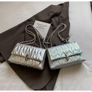 Détails de sacs à main matelassés argentés et holographiques sur un blazer chic