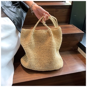 Detail of hand-woven straw tote bag with dense texture in a minimalist lifestyle setting