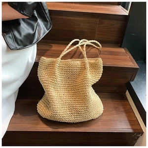 Detailed close-up showing the dense woven texture of this beige straw tote bag