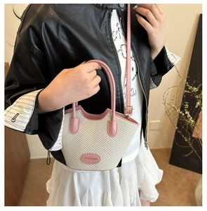 Detail der gewebten Beuteltasche mit rosa Lederbesatz und Logo am Modell gezeigt