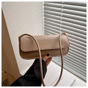 Detail view of khaki leather baguette bag with elegant golden embossed fashion lettering