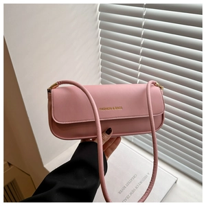 Detailed view of a pink baguette shoulder bag with gold FASHION & BAGS logo text