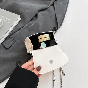 Detailed interior of a beige mini leather bag showing lipstick and makeup storage