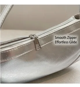 Detail of a smooth silver metal zipper on a textured silver faux leather shoulder bag