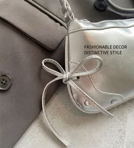Detail of silver tote bag with decorative side bow and metallic rivet studs